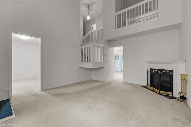 unfurnished living room with carpet flooring and a high ceiling