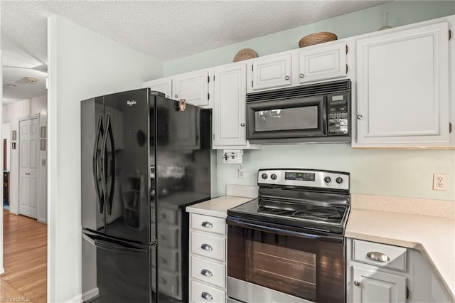 kitchen with a textured ceiling, white cabinets, light countertops, light wood-type flooring, and black appliances