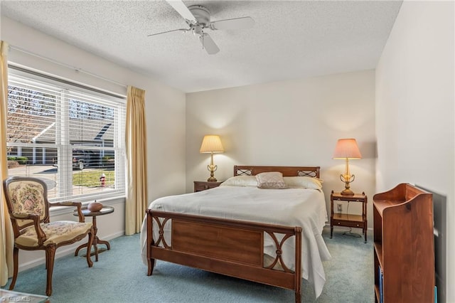 carpeted bedroom with ceiling fan, baseboards, and a textured ceiling