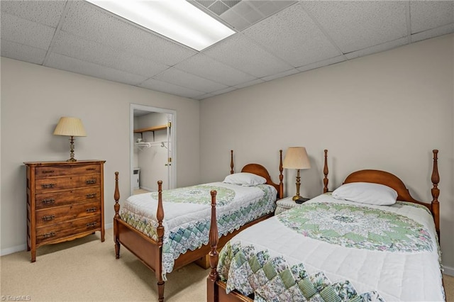 bedroom featuring light carpet, a closet, and a paneled ceiling