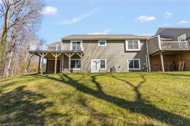 rear view of house featuring a lawn and a deck