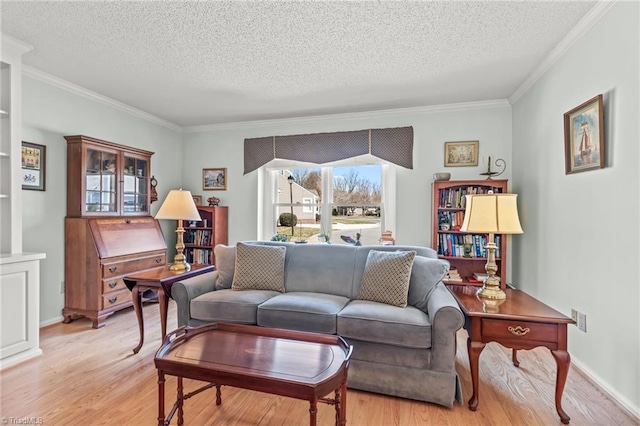 living room featuring light wood-style floors, ornamental molding, and a textured ceiling