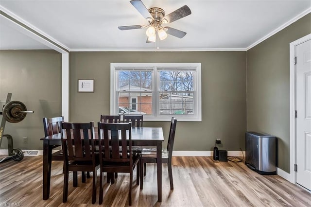 dining area featuring light hardwood / wood-style flooring, ornamental molding, and ceiling fan