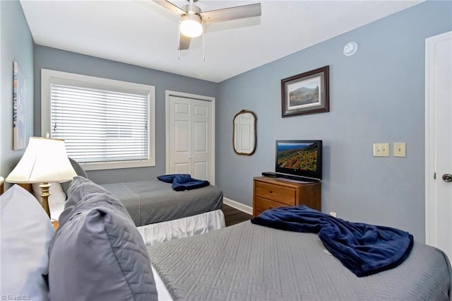 bedroom with ceiling fan, dark wood-type flooring, and a closet