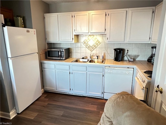 kitchen featuring white cabinetry, sink, dark wood-type flooring, backsplash, and white appliances