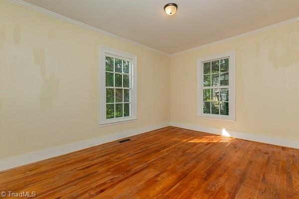 112 S Caldwell St, Salisbury, NC 28144 - empty room with wood finished floors, ornamental molding, and baseboards