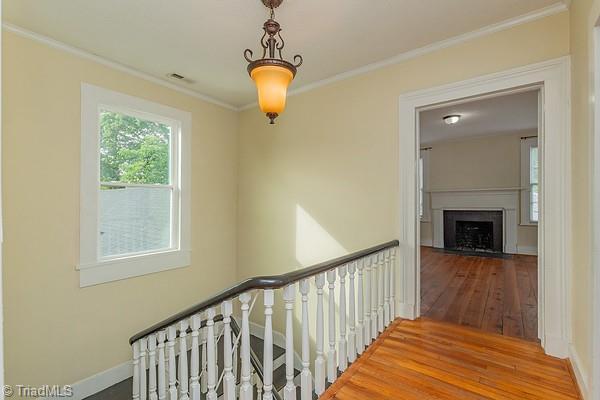 112 S Caldwell St, Salisbury, NC 28144 - staircase with wood-type flooring, crown molding, baseboards, and a fireplace with flush hearth