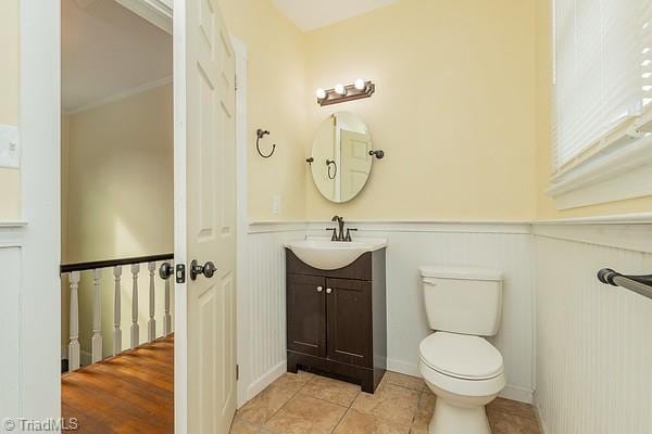 112 S Caldwell St, Salisbury, NC 28144 - bathroom featuring vanity, wainscoting, toilet, tile patterned floors, and a decorative wall
