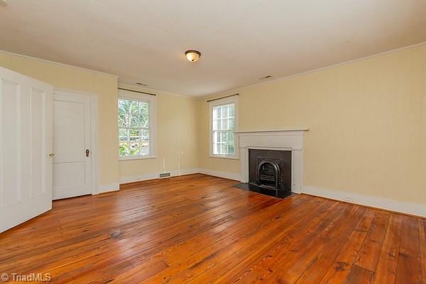 112 S Caldwell St, Salisbury, NC 28144 - unfurnished living room featuring wood-type flooring, a fireplace with flush hearth, and baseboards