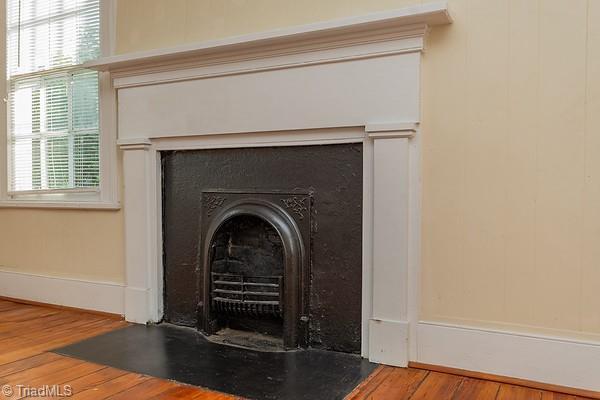 112 S Caldwell St, Salisbury, NC 28144 - detailed view of a fireplace with flush hearth, wood finished floors, and baseboards