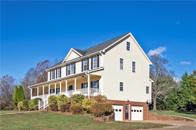 view of front of house with a front lawn, a porch, and a garage