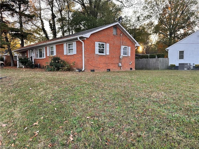 view of side of property with central AC and a yard