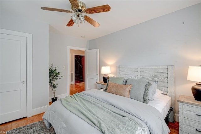 bedroom featuring wood finished floors, baseboards, and ceiling fan