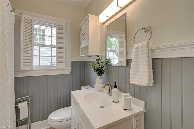 bathroom featuring wainscoting, vanity, and toilet