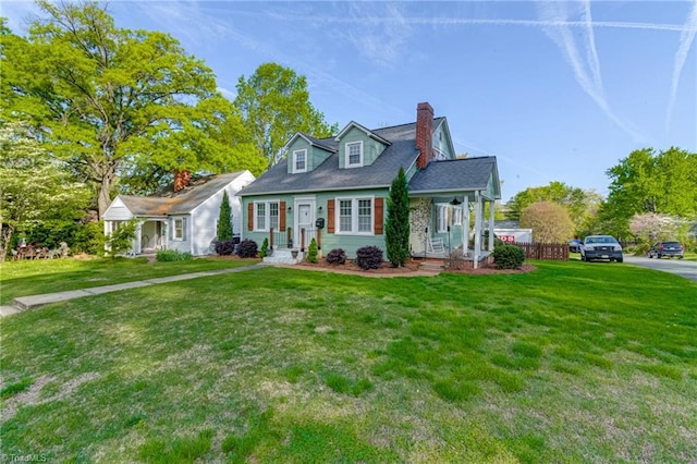 new england style home with a chimney and a front yard