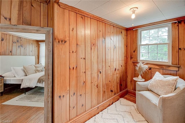 sitting room featuring wood walls and hardwood / wood-style flooring