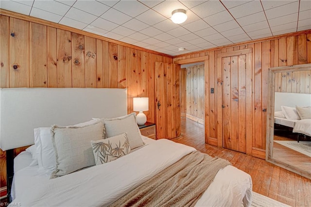 bedroom featuring wood-type flooring and wood walls