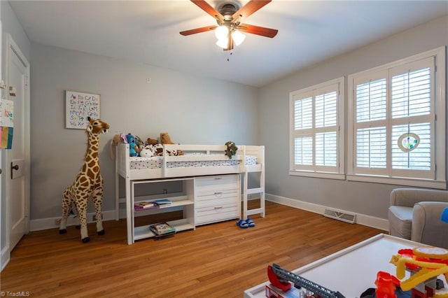 bedroom featuring light wood finished floors, baseboards, and a ceiling fan