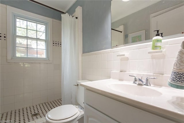 bathroom featuring tile walls, a shower stall, vanity, and toilet