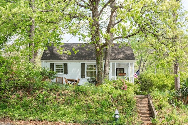 cape cod home featuring a porch