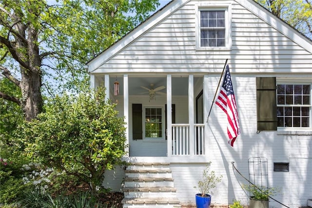 view of front of property with ceiling fan, covered porch, and brick siding
