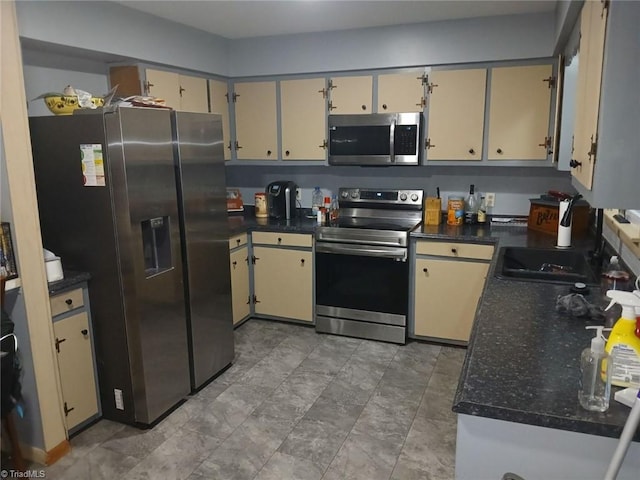 kitchen with cream cabinetry, sink, and stainless steel appliances