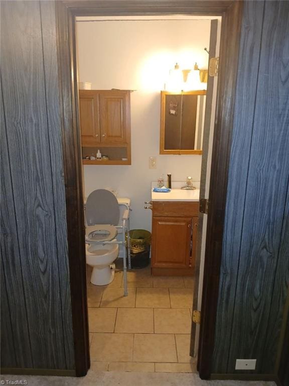 bathroom with toilet, vanity, and tile patterned floors