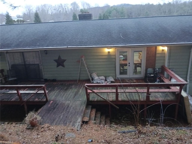 rear view of property featuring a wooden deck and french doors