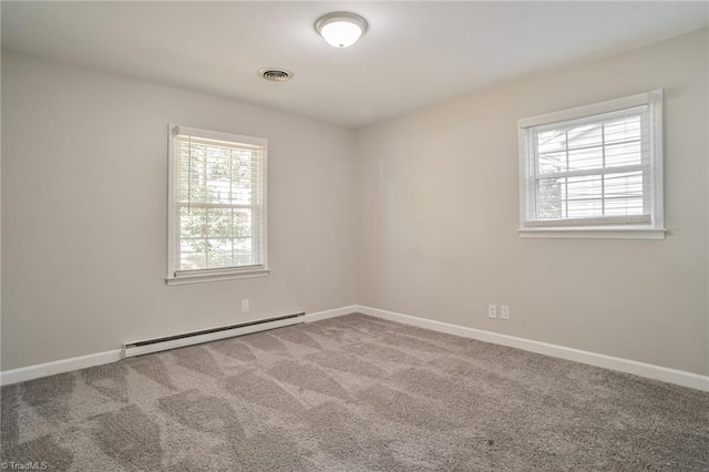 empty room with carpet, a healthy amount of sunlight, and a baseboard heating unit