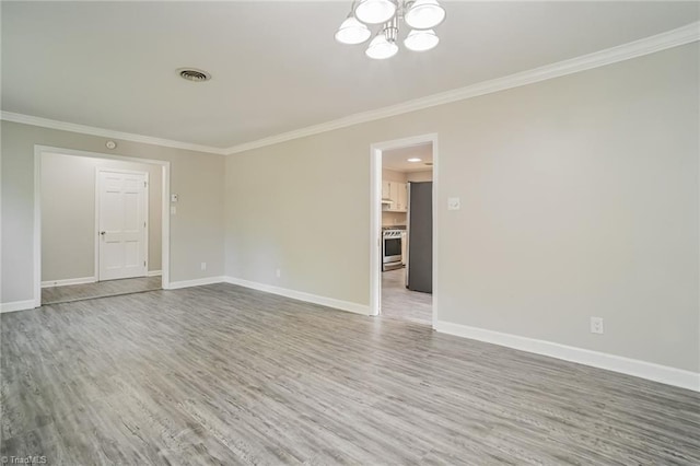 unfurnished room featuring crown molding, wood-type flooring, and an inviting chandelier