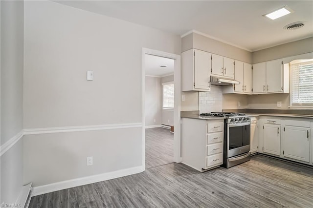 kitchen featuring tasteful backsplash, ornamental molding, stainless steel gas stove, light hardwood / wood-style floors, and white cabinetry