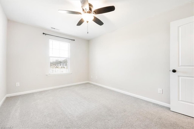 carpeted spare room with ceiling fan, visible vents, and baseboards