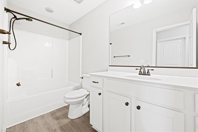 full bath with visible vents, toilet, wood finished floors, vanity, and shower / washtub combination