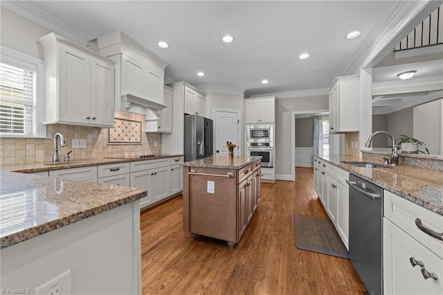 2507 Duck Club Rd, Greensboro, NC 27410 - kitchen featuring stainless steel appliances, crown molding, light stone counters, wood finished floors, and recessed lighting