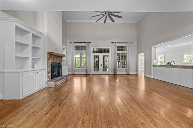 2507 Duck Club Rd, Greensboro, NC 27410 - unfurnished living room with ceiling fan, light wood-style floors, a high ceiling, ornamental molding, and a stone fireplace