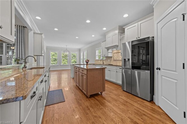 2507 Duck Club Rd, Greensboro, NC 27410 - kitchen featuring stainless steel fridge, crown molding, stone counters, light wood-style flooring, and backsplash