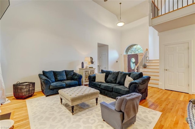 living room with hardwood / wood-style flooring and a high ceiling