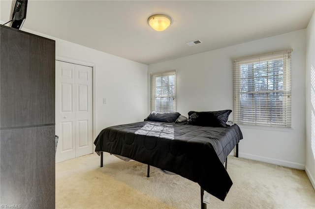 bedroom featuring light colored carpet and a closet