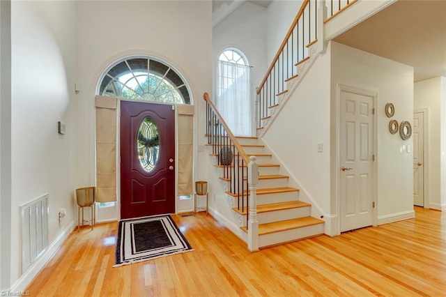 foyer with a high ceiling and wood-type flooring