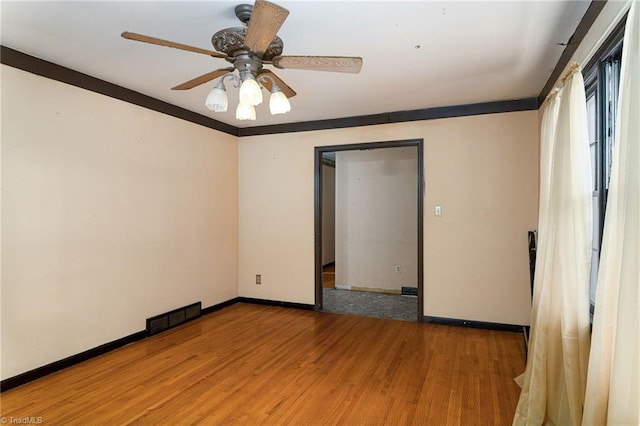 empty room featuring hardwood / wood-style floors, ceiling fan, and ornamental molding