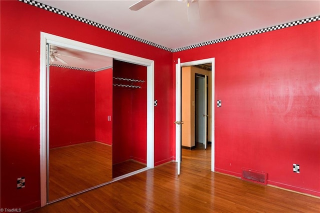 unfurnished bedroom with ceiling fan and hardwood / wood-style flooring