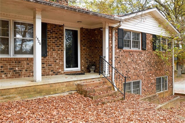 view of exterior entry featuring covered porch