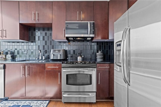 kitchen with light hardwood / wood-style flooring, sink, appliances with stainless steel finishes, and decorative backsplash