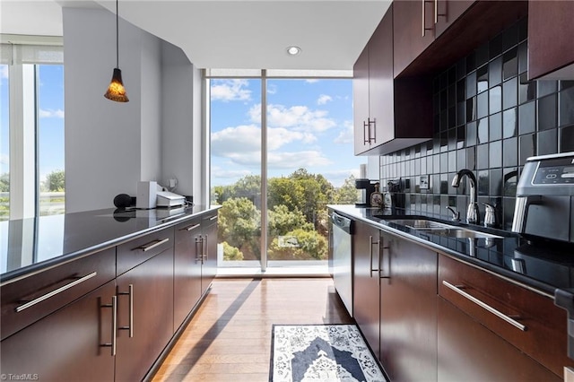 kitchen with light wood-type flooring, plenty of natural light, decorative backsplash, and hanging light fixtures