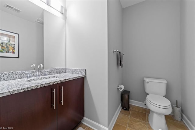 bathroom with tile patterned flooring, vanity, and toilet