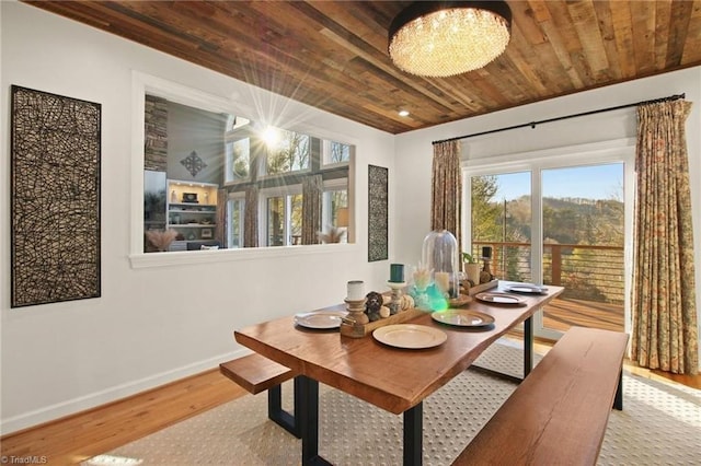 dining space featuring an inviting chandelier, wood ceiling, and light hardwood / wood-style flooring