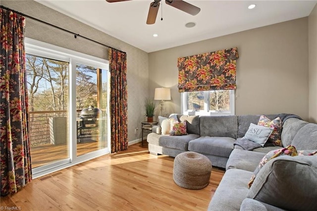 living room with ceiling fan and light hardwood / wood-style flooring