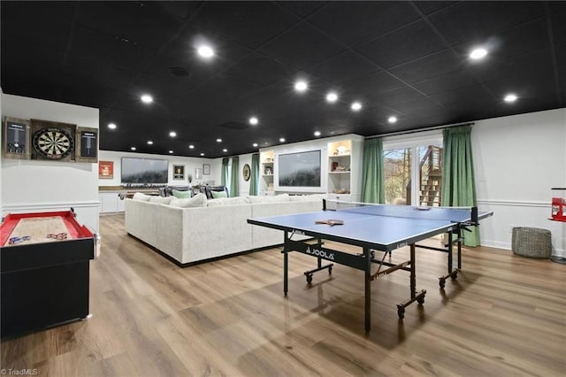 recreation room featuring light wood-type flooring and built in shelves