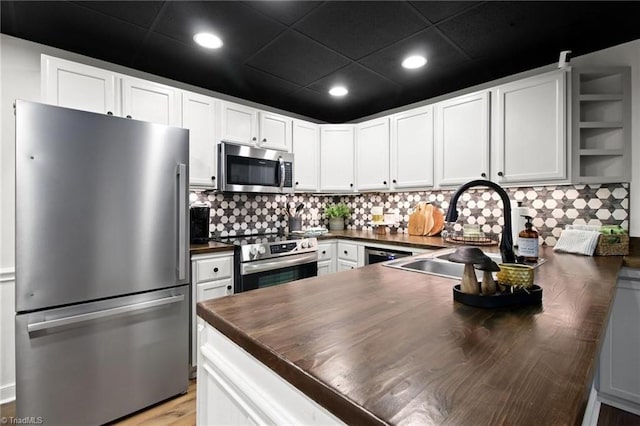 kitchen with sink, white cabinets, appliances with stainless steel finishes, and a paneled ceiling