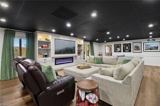 home theater room featuring built in features and hardwood / wood-style flooring